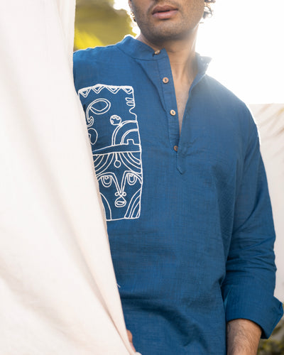 Man wearing a blue kurta with white embroidery on a plain background