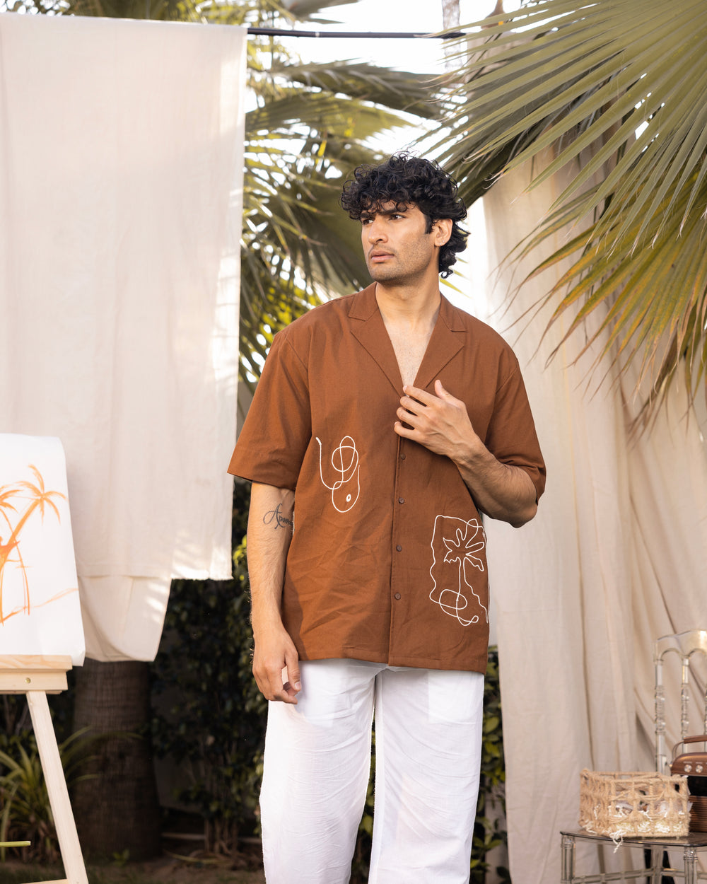 Man wearing a brown shirt with white patterns outdoors
