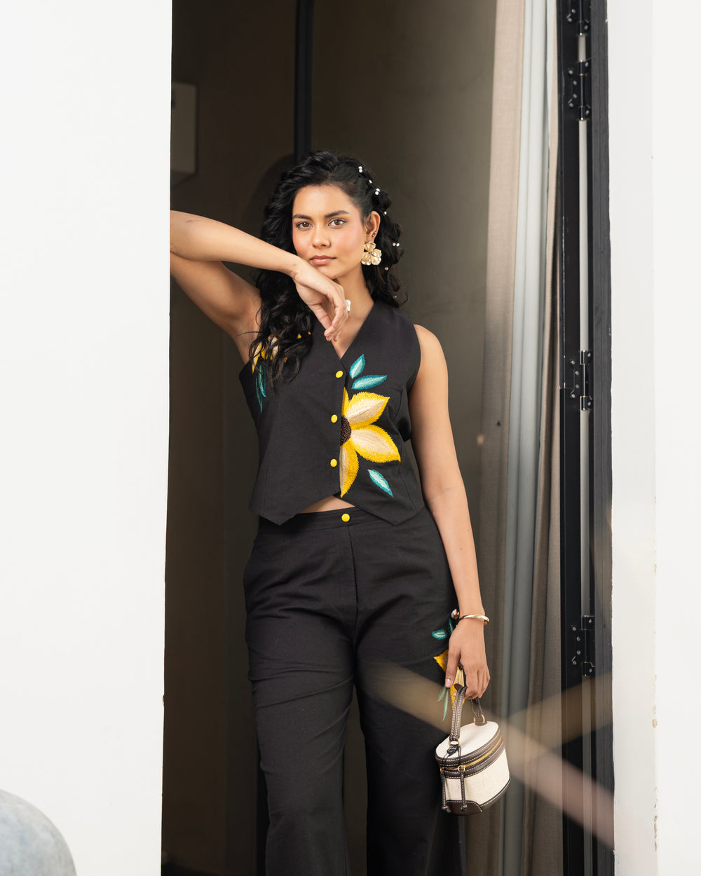 Detailed shot of black embroidered pants with yellow floral design in women’s co ord set