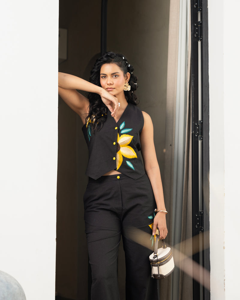 Detailed shot of black embroidered pants with yellow floral design in women’s co ord set