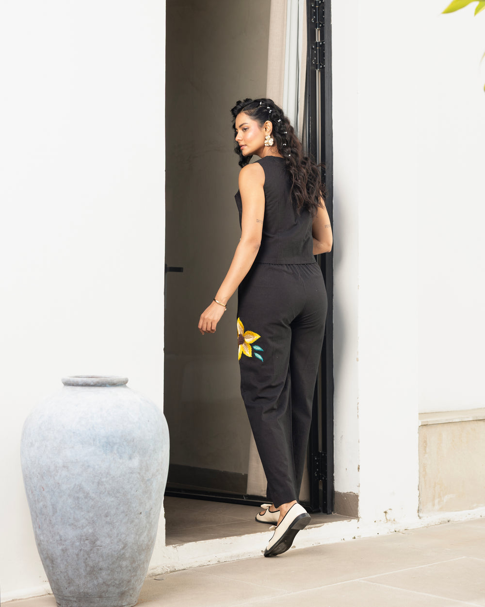 Detailed shot of black embroidered pants with yellow floral design in women’s co ord set