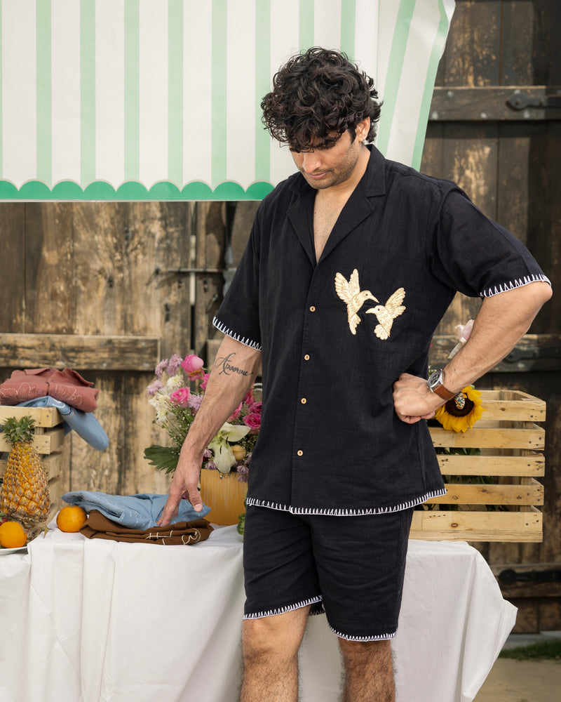 Man wearing a black shirt with butterfly design outdoors