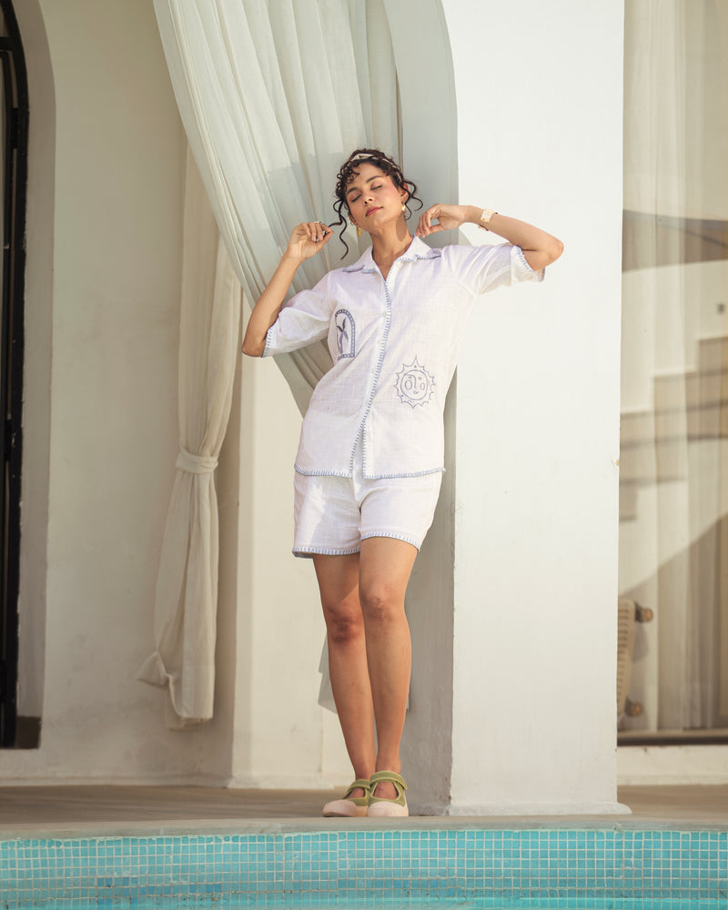 Women wearing white embroidered co ord set with shorts in a resort style setting