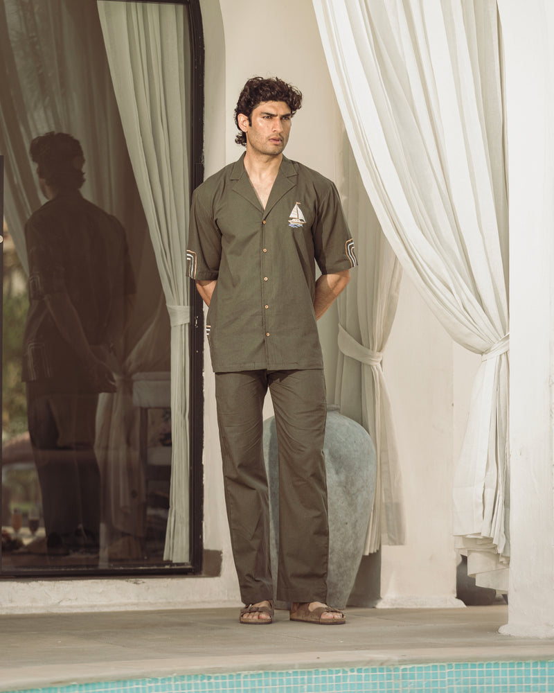 Man standing by a poolside with curtains in the background