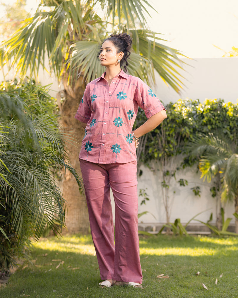 Woman wearing a pink outfit with floral patterns in an outdoor setting