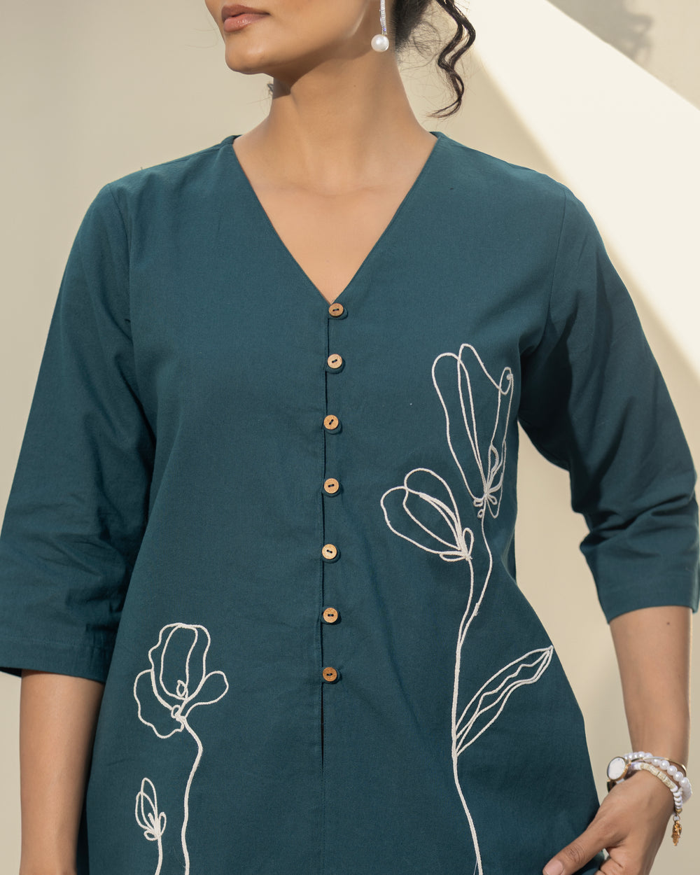 Teal kurta with floral embroidery on a neutral background