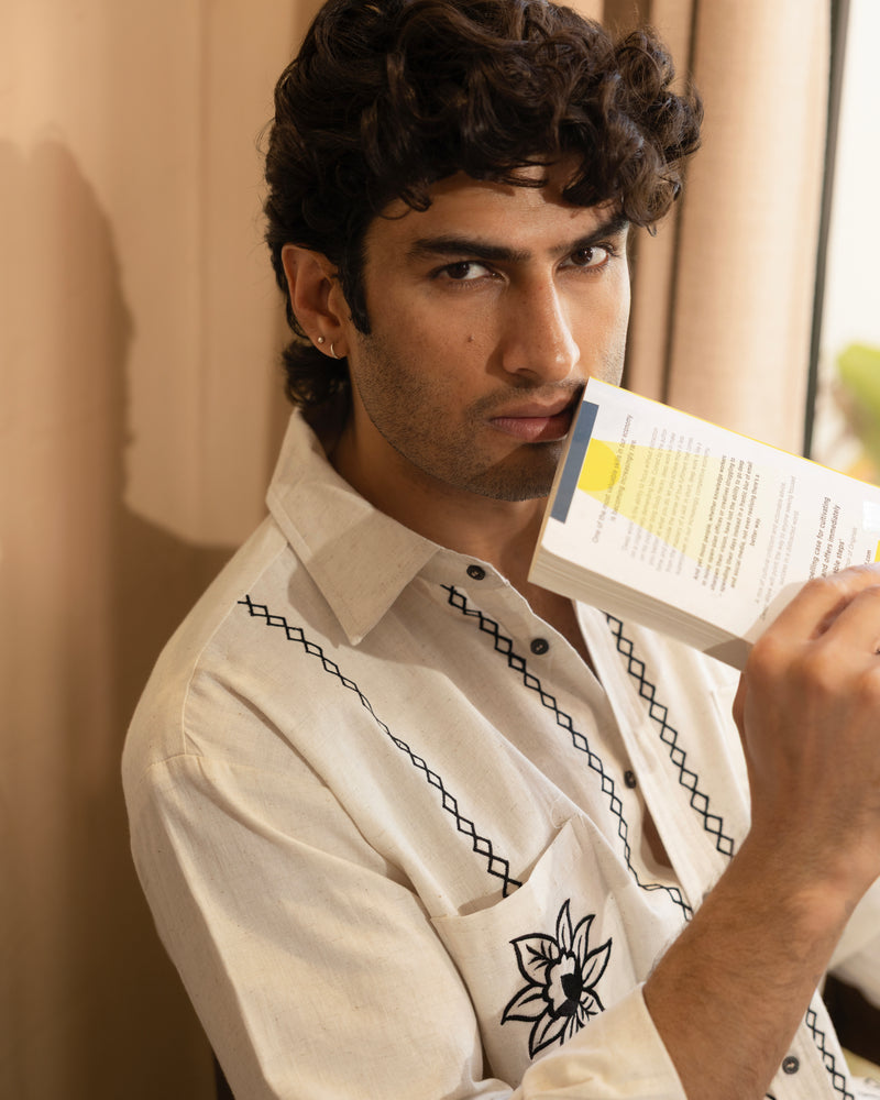 Man holding a book with a neutral background