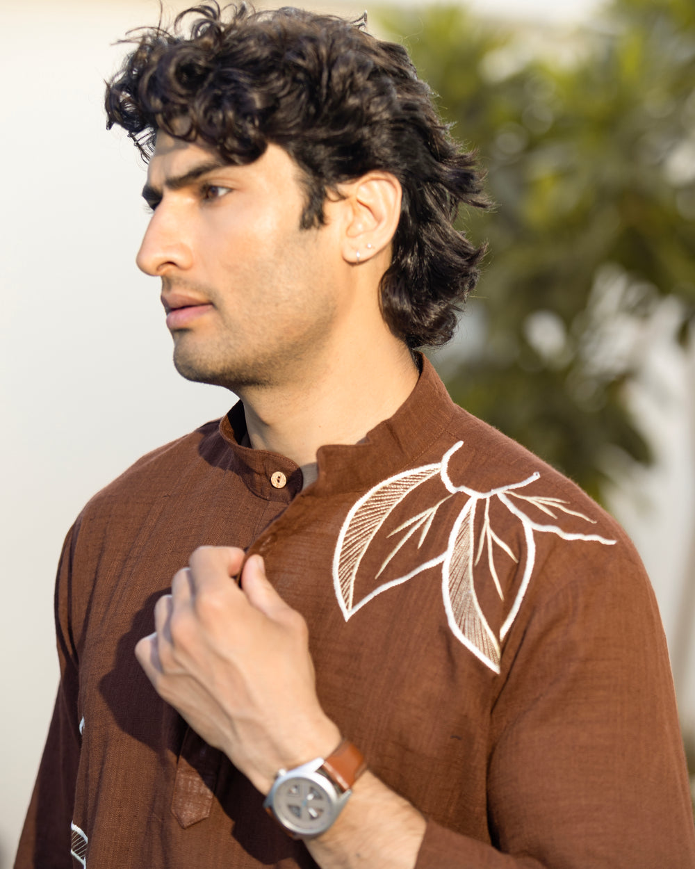 Man wearing a brown shirt with leaf design outdoors