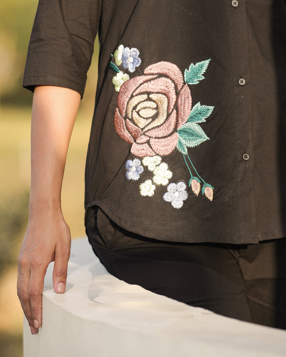 Brown shirt with floral embroidery on a blurred background